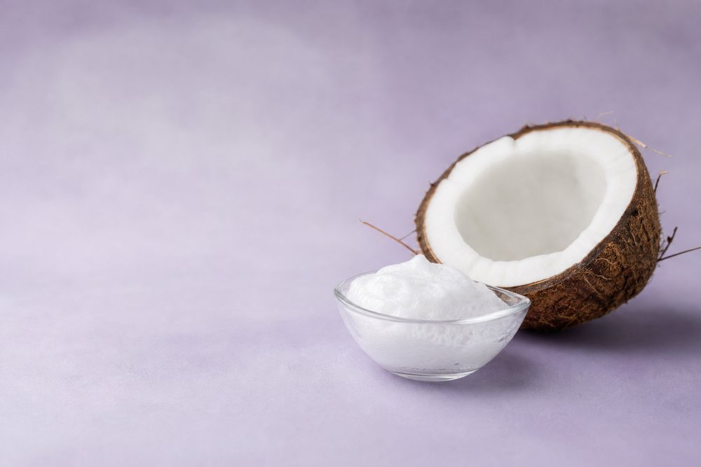 Halved coconut beside a dish of foam